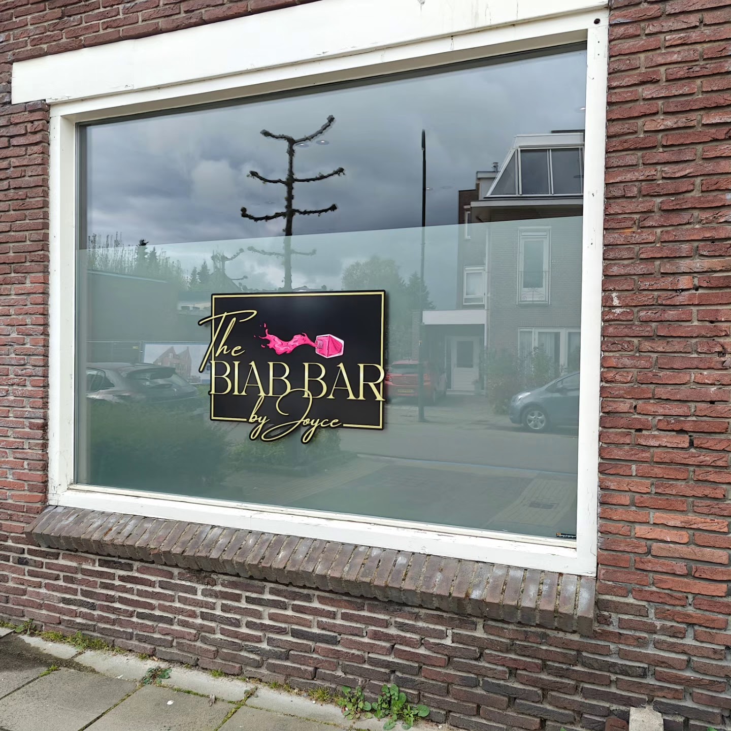 Het raam van de studio met het logo van The Biab Bar by Joyce op het glas